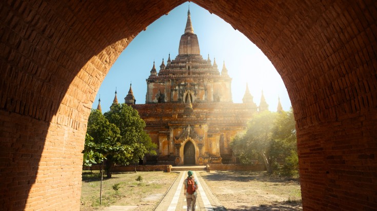 Traveler walking along the road of Htilominlo temple in a sunny day. Traveler walking along the road of Htilominlo temple in a sunny day.