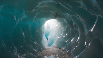 Light passing through the ice caves of Mýrdalsjökull glacier in Iceland. 