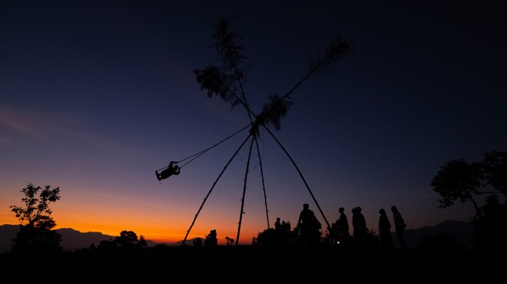 People playing on a bamboo swing