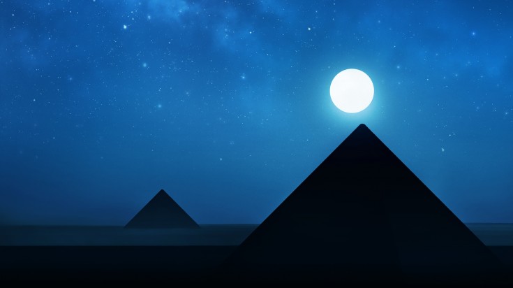 The night sky in with a moon and pyramid seen while sightseeing in Egypt.