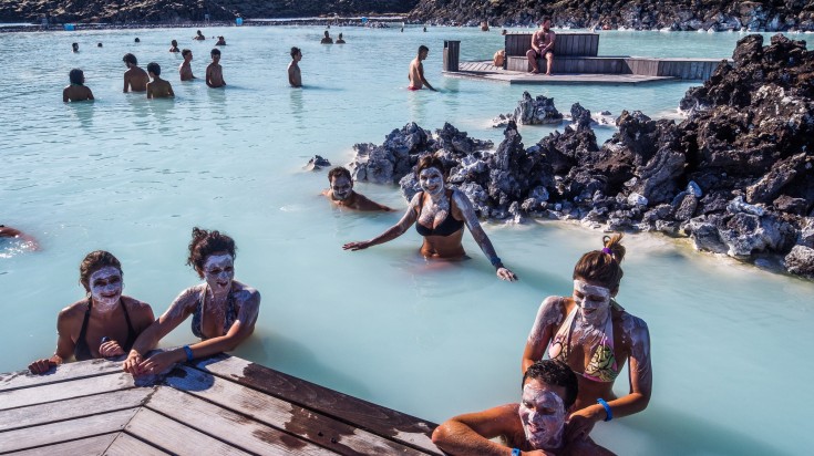 People applying masks and relaxing in the Blue Lagoon.