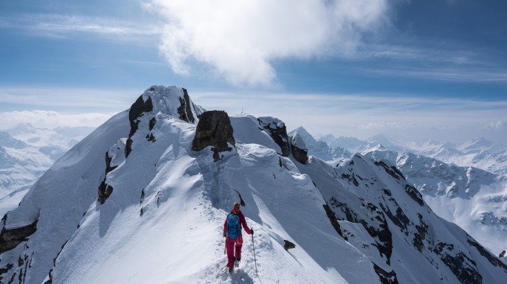 A skier climbing to the top of The Fluela Wisshorn surrounded by mountains. A skier climbing to the top of The Fluela Wisshorn surrounded by mountains.