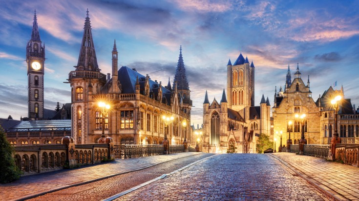The historic city of Ghent under the night sky and bright lights.