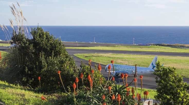 A plane on the tarmac in an airport next to the sea