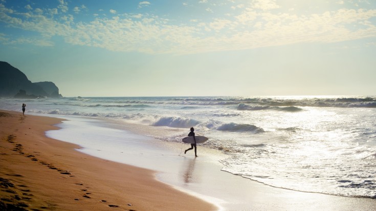 Surfer at the Atlanctic ocean beach. Algarve, Portugal