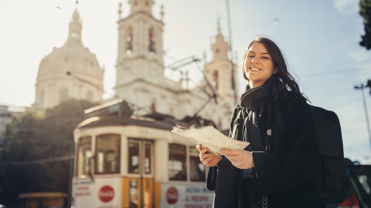 Woman holding guide and exploring charming country