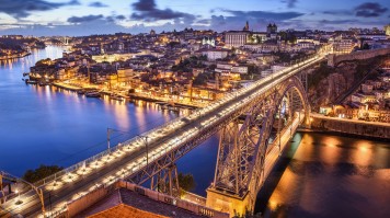 Cityscape in the evening with all the lights on with a bridge in view