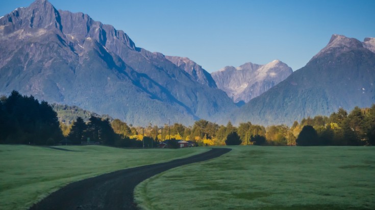 Landscape of Pumalin Park with a snowy volcano on a sunny day in Chilean