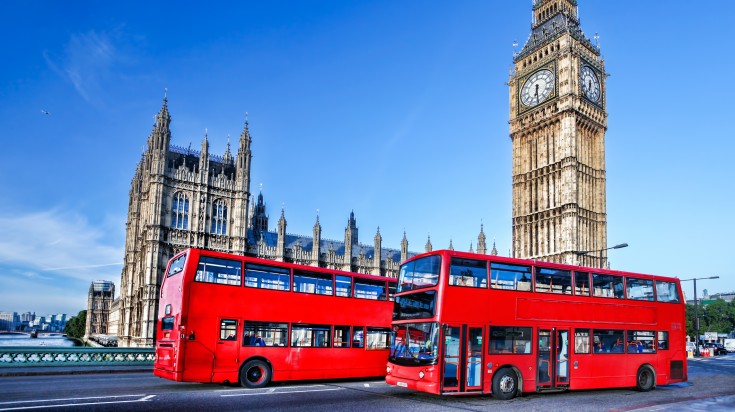 Two double-decker London buses spotted in front of Big Ben.