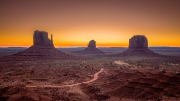 An evening view of the Grand Canyon with orange sky. 