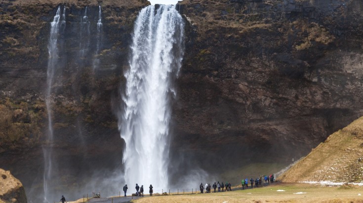 Tourist walk near the giant Seljalandsfoss waterfall