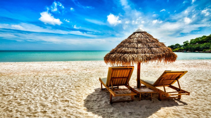 Two lounge chairs under the tent on beach on a cloudy day at Sihanoukville