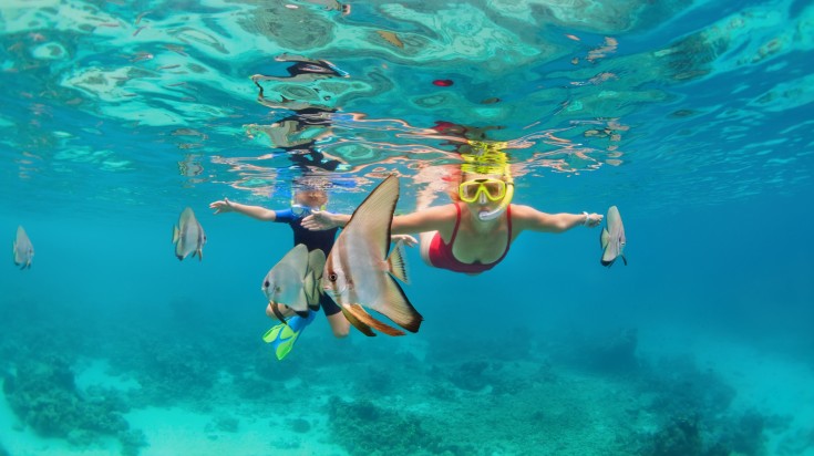 A mother and child snorkeling together in the Maldives.