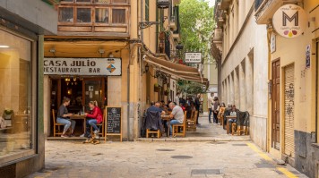 A typical culinary scene in Palma de Mallorca Restaurant terrace full of diners at noon in the historic center of Palma d