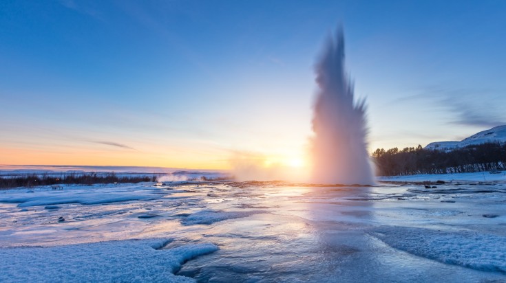 Strokkur Geyser and its surrounding winter landscape.