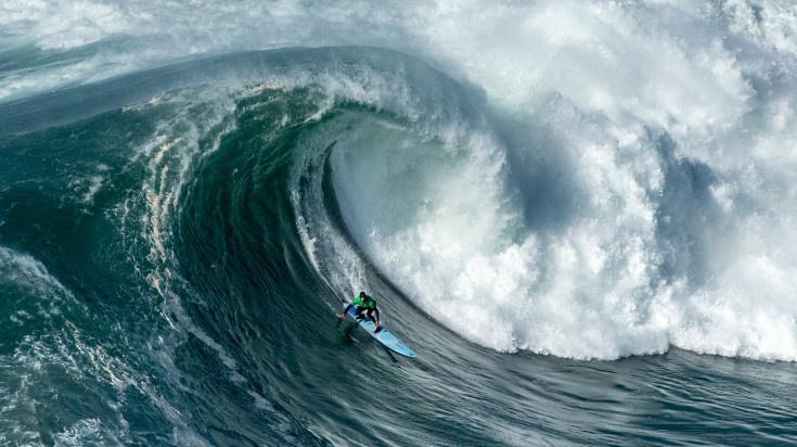 Surfer catching a big wave on Nazare Cannon in Portugal in March.