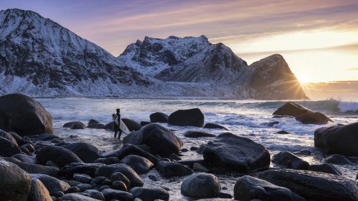 Surfer withstand high waves at Unstad beach in Norway during winter