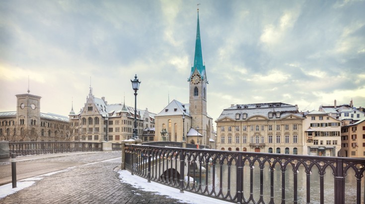 A view of Zurich with a bridge and buildings in the background.