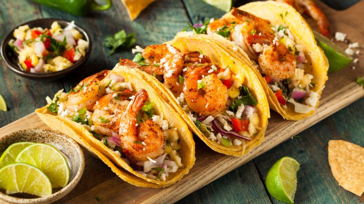 A taco is a traditional Mexican dish consisting of a corn or wheat tortilla folded or rolled around a filling. Tacos al Pastor