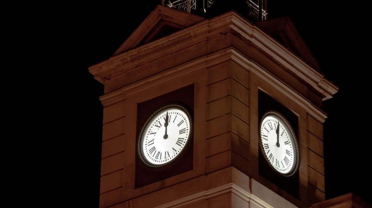 The clock tower at Puerta del Sol square showing midnight.