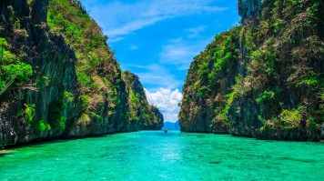 Tropical landscape with rock islands and a lonely boat at El Nido, Palawan