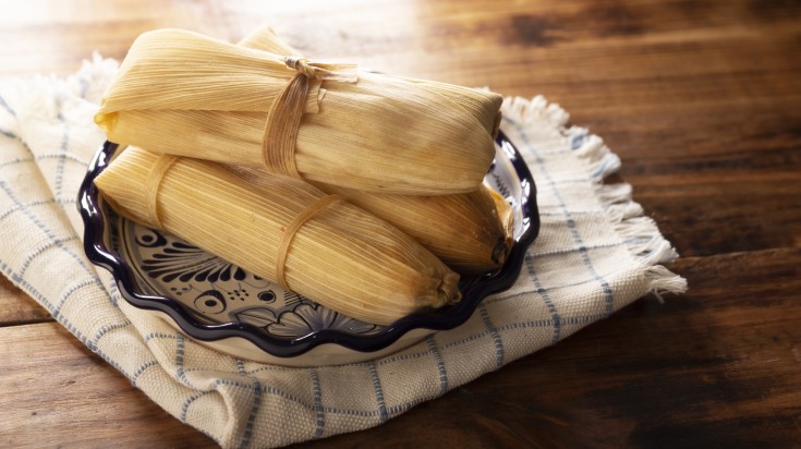 Three steamed tamales on a plate.