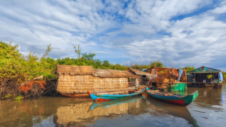 Two boats in Tonle Sap Lake on a cloudy day in Cambodia.