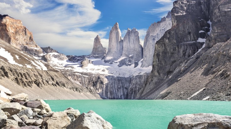 Three towering rock formations against the backdrop of turquoise blue lake