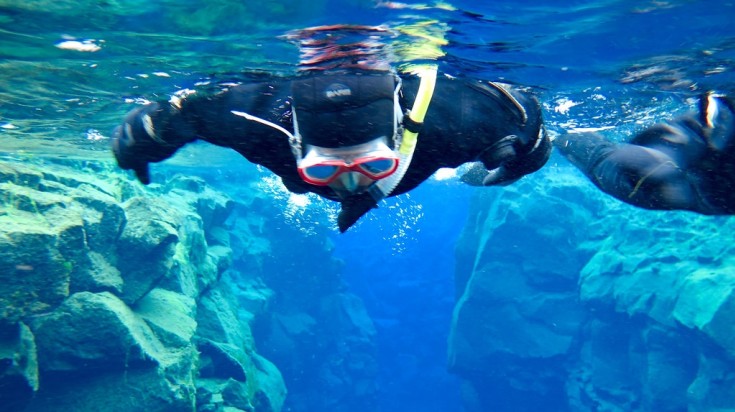 Tourist snorkeling at Silfra Fissure.