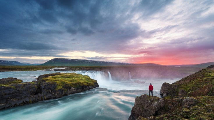 Tourist staring right at the beautiful Godafoss waterfalls.