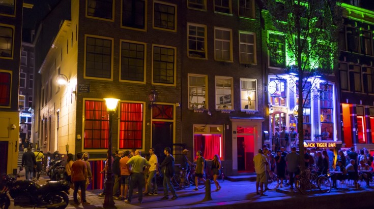 Tourists in an area lined up with pubs in Amsterdam.