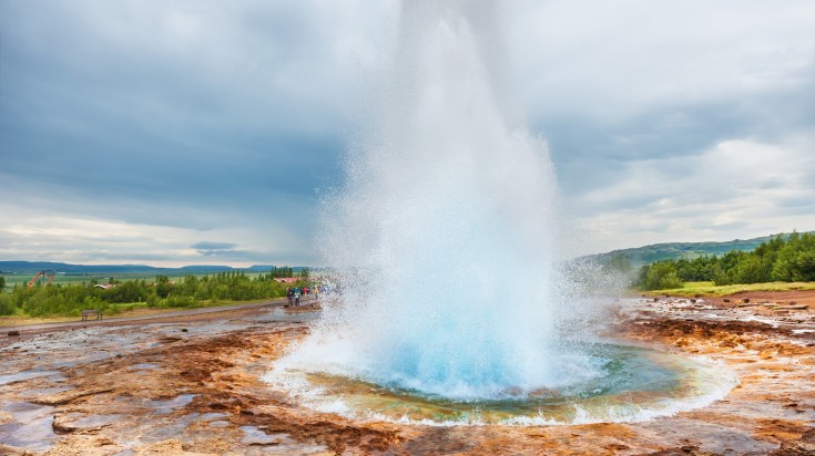 Tourists watching Strokkur Geysir erupting, one of the things to do in Icel