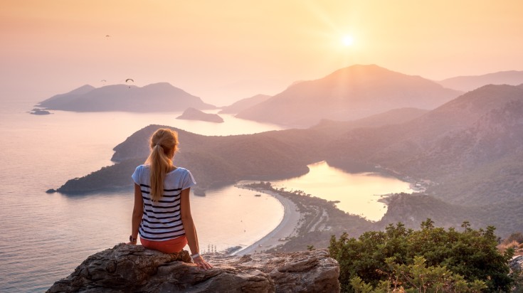 A teenage girl looks at the Turkish landscape during sunset.