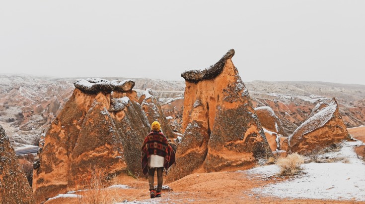 A girl at Fairy chimneys surrounded by snow in Turkey in November.