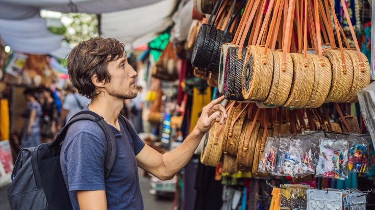 A tourist man looking at handicrafts in Ubud Art Market.