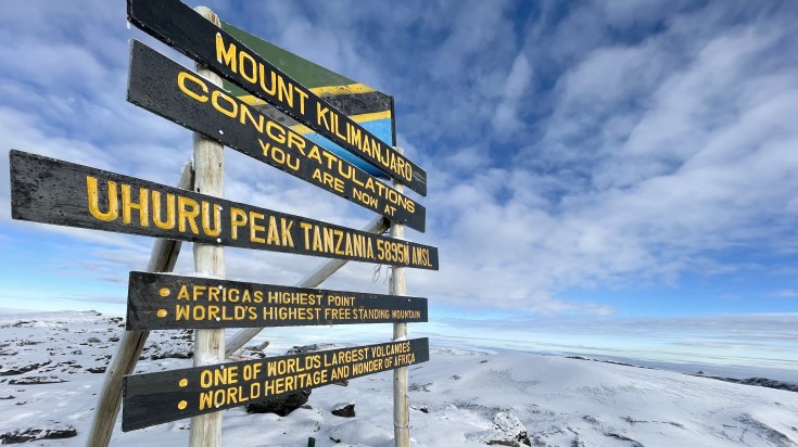 sign board at Uhuru peak, the summit of Mount Kilimanjaro, during winter.