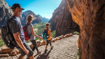 Three hikers on a trail in Zion National Park in USA