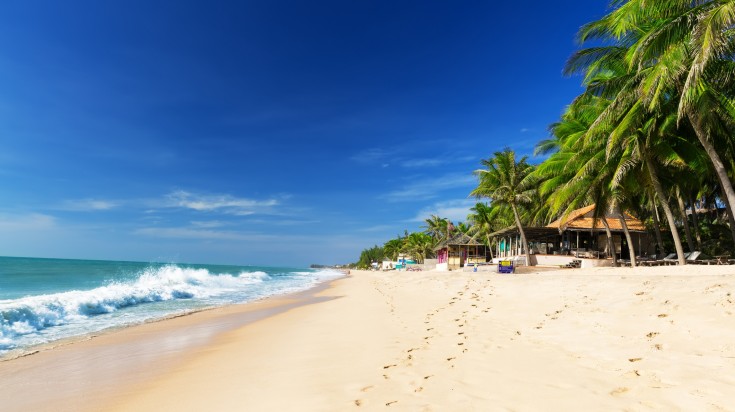 Many visitors head to the beach to escape the humid weather and with fewer crowds, you can have an even better time. Mui Ne white sandy beach in Vietnam with footprints in the sand.