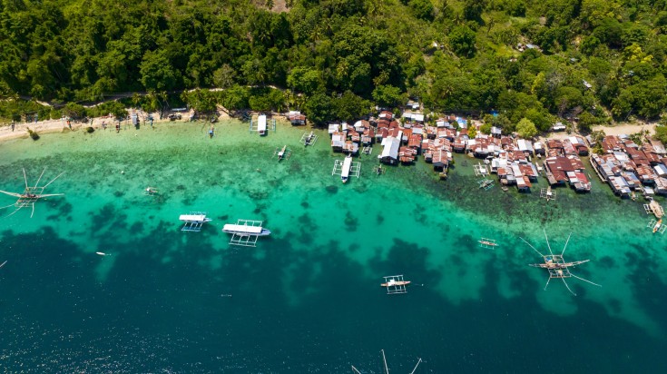 Bird's eye view of boats and houses on water in the Philippines in April.