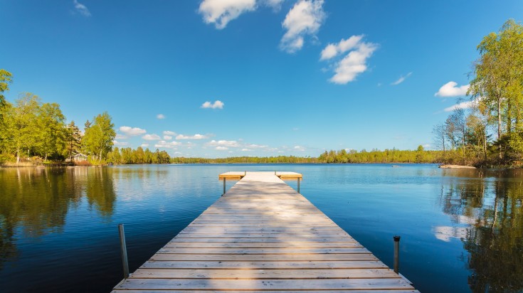 Wooden jetty on a clear summer day in Smaland in Sweden in August.