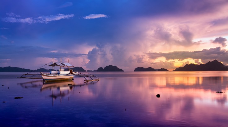 People on a banca boat watching the sunset in the Philippines in April.