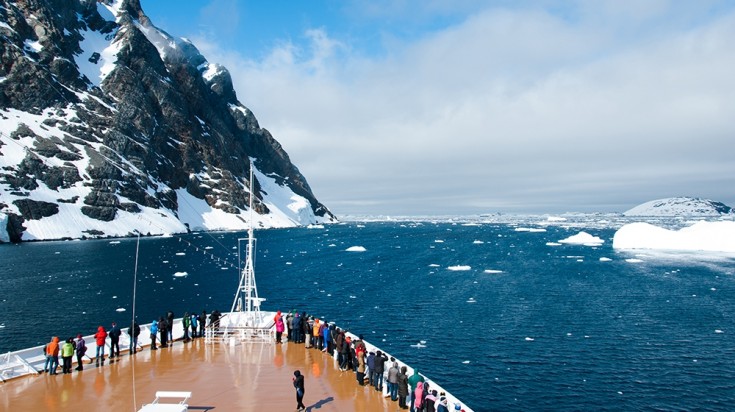 A cruise pases through a mountain in Antarctica.