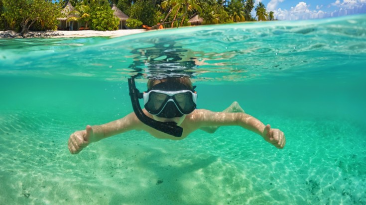 A boy snorkels underwater in the Maldives in July .