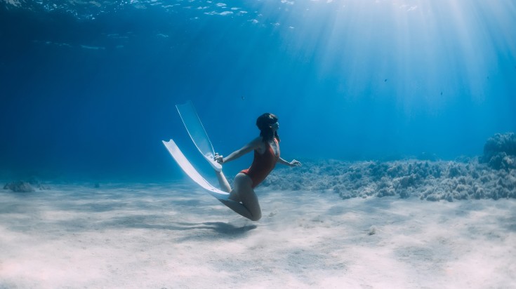 Woman diver posing underwater in Nungwi beach.