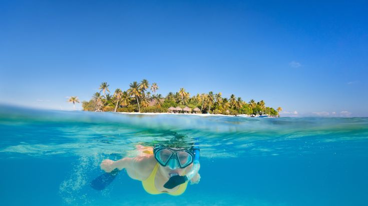 Kendwa Beach offers snorkeling opportunities and dhow boat trips along the picturesque coast. Woman snorkeling in the tropical paradise of Kendwa Beach