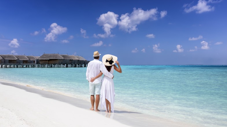 A couple enjoying their time at a tropical beach, one of the best places to visit in the Maldives.
