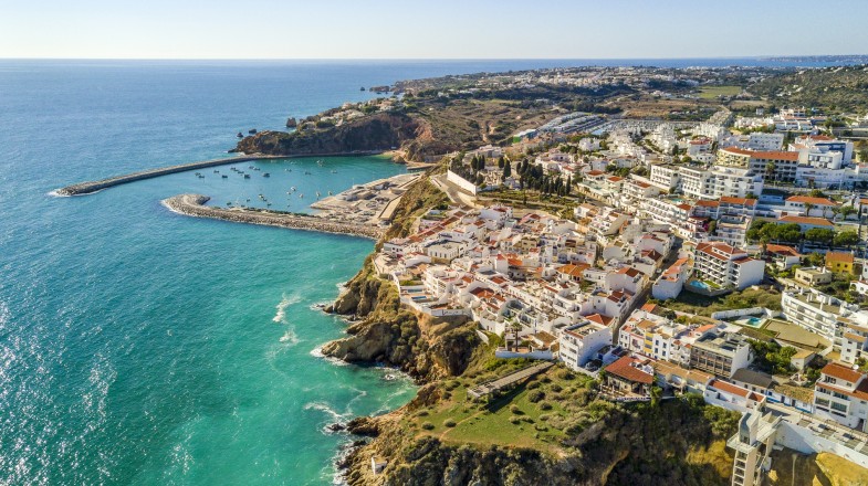 The coastal town with beautify white-washed buildings next to a blue sea.