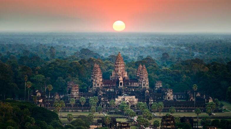 Immerse yourself in the vibrant greens of the country while you travel to Cambodia in August. A bird eye view of the Angkor Wat temple surrounded by greenery at sunset in Cambodia in August.