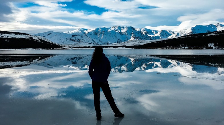 A tourist admires the stunning snowy-mountain scenery during winter in Argentina