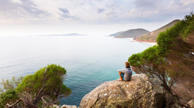 A man enjoying the panoramic view of the coastline in Australia.